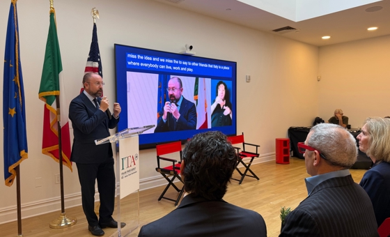 Relatore al podio durante il seminario internazionale sull’autismo del 10 settembre 2026 presso l’Italian Trade Agency di Manhattan, con pubblico in sala e contributo video proiettato sullo schermo.