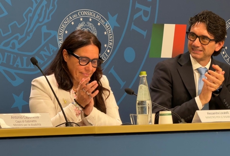A sinistra, il Ministro per le Disabilità Alessandra Locatelli; a destra, Serafino Corti, coordinatore del Comitato tecnico scientifico dell’OND. Sul tavolo sono presenti microfoni, documenti e una bottiglia d’acqua. Sullo sfondo è visibile il logo della Presidenza del Consiglio dei Ministri e la bandiera italiana.